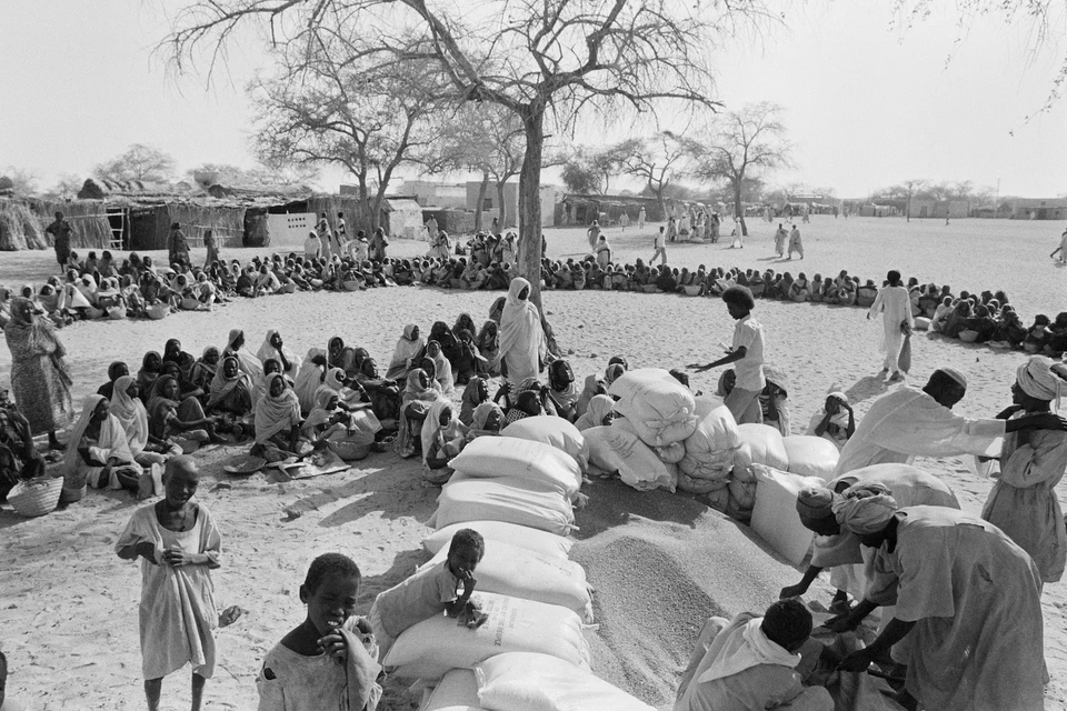 أسر تنتظر توزيع مساعدات الذرة، السودان، 1985. تصوير هيوز دي لاتود.